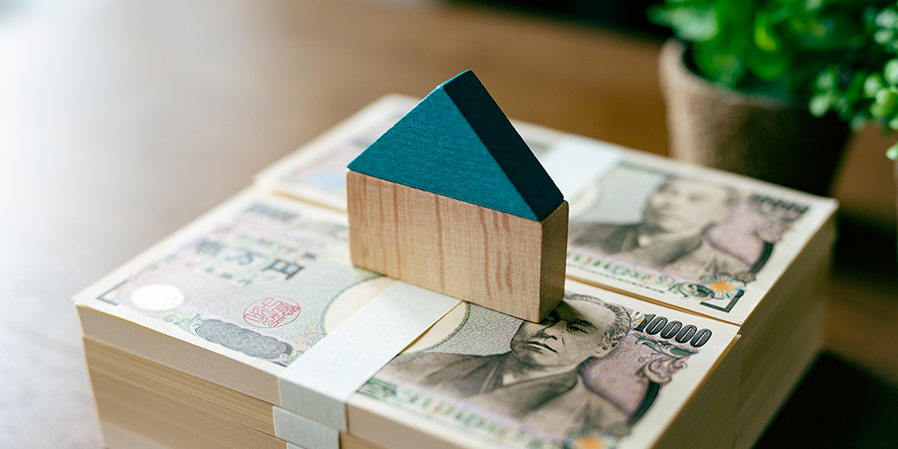 お金の上にある家の模型