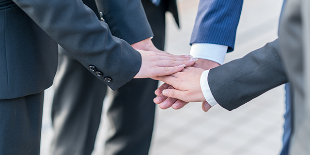 専門家達が手を重ねる