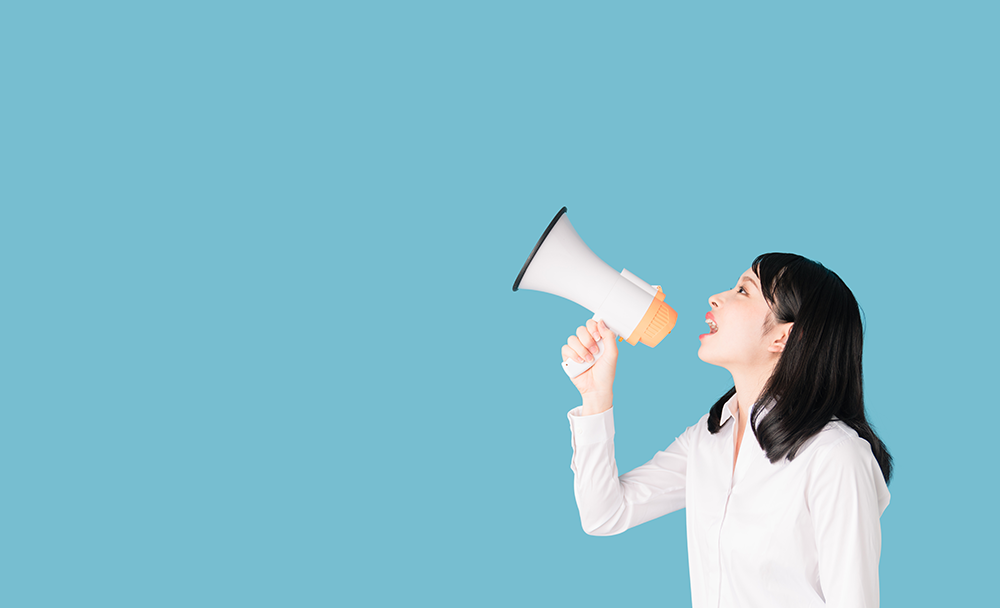 拡声器でアナウンスする女性
