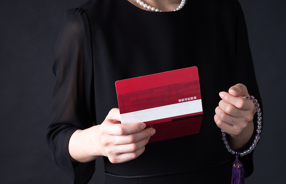 銀行通帳の残高を確認する葬儀参列者