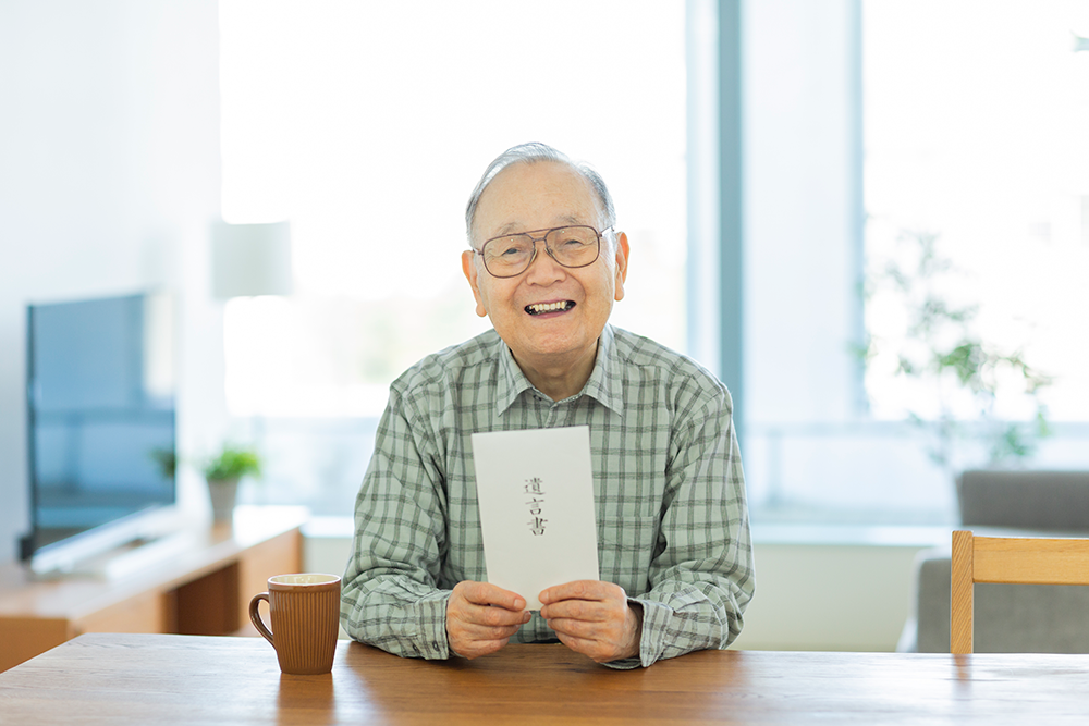 遺言書を持つ老人男性